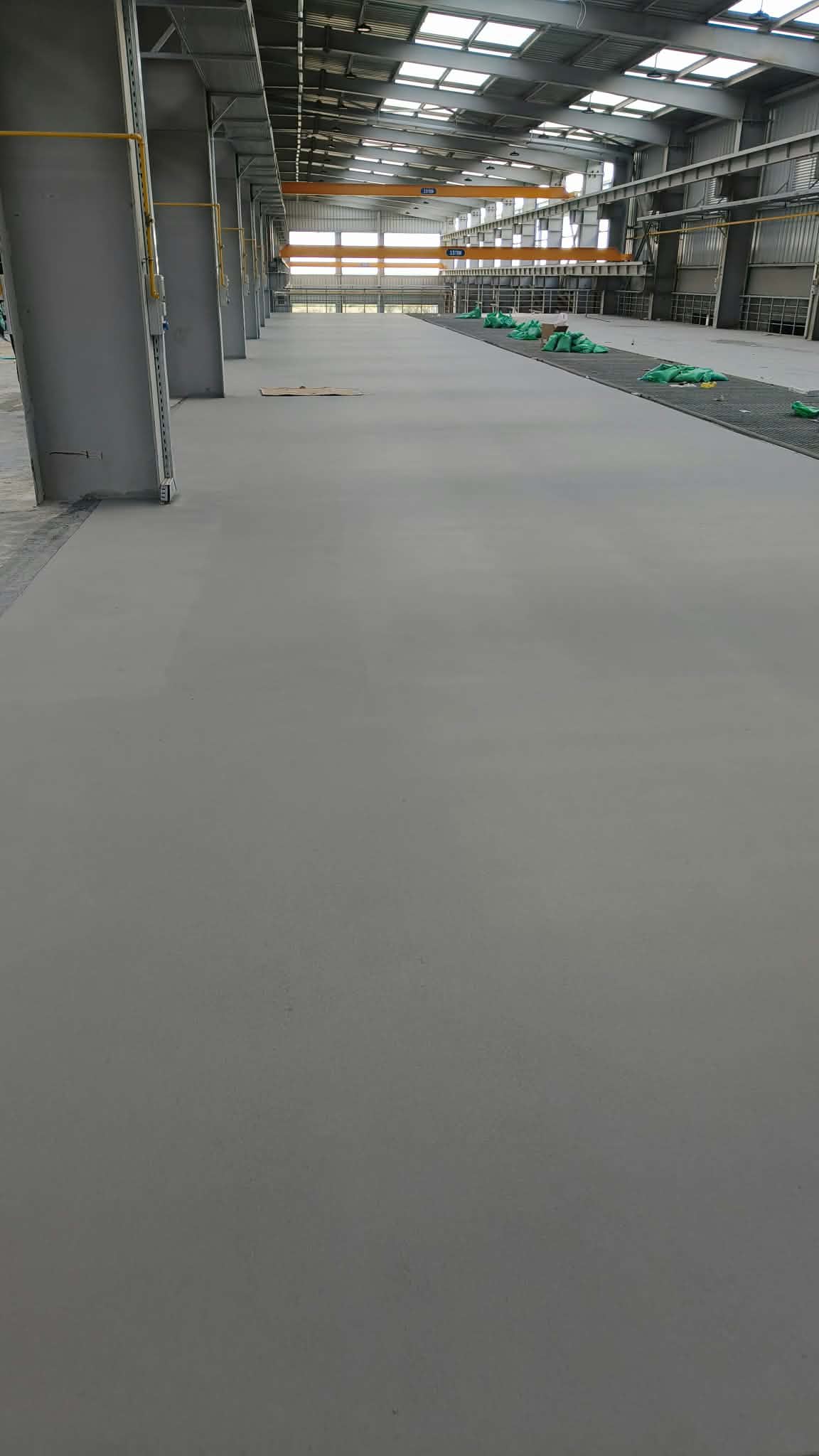 Finished light grey epoxy floor in a large industrial warehouse