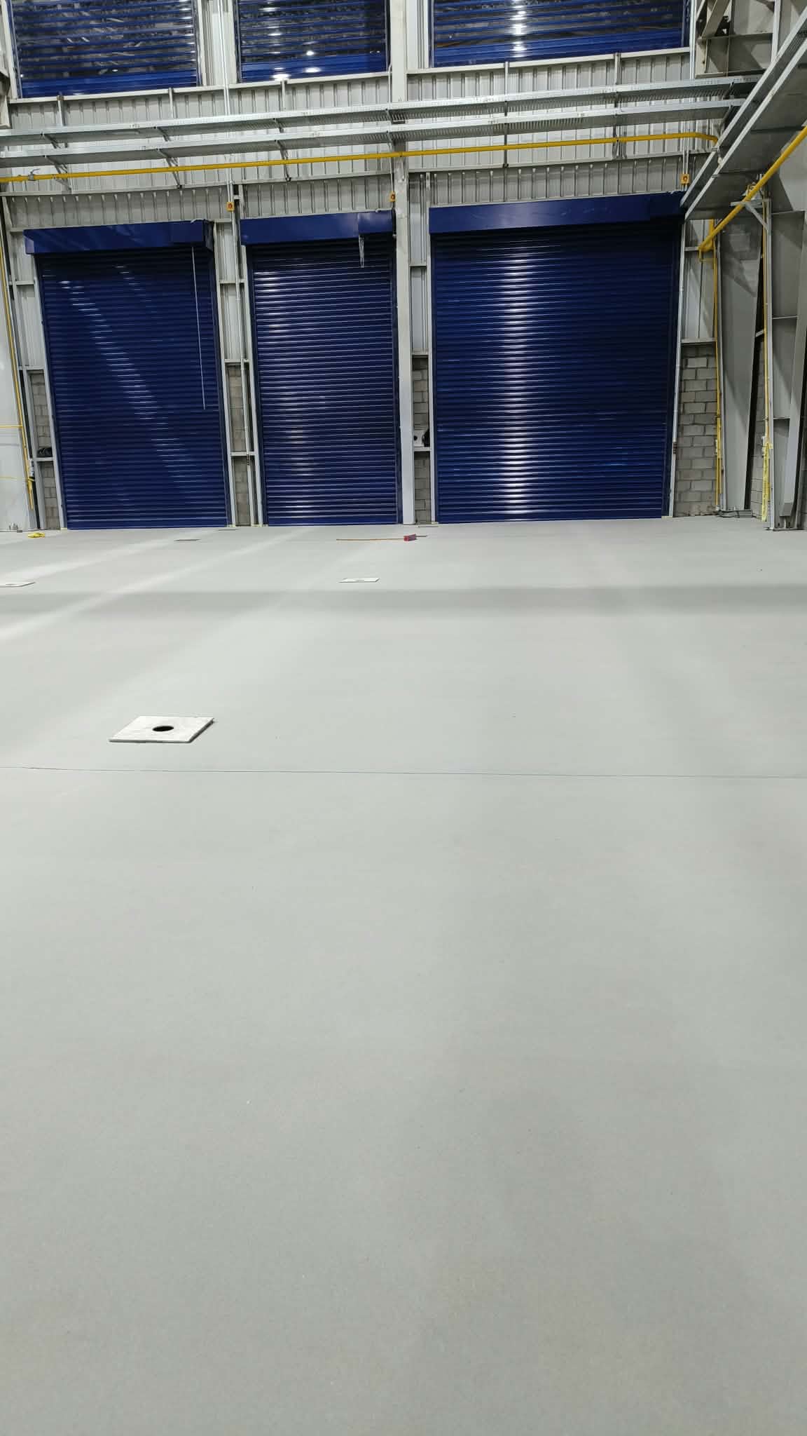 Finished epoxy floor in a factory loading bay with roll-up doors