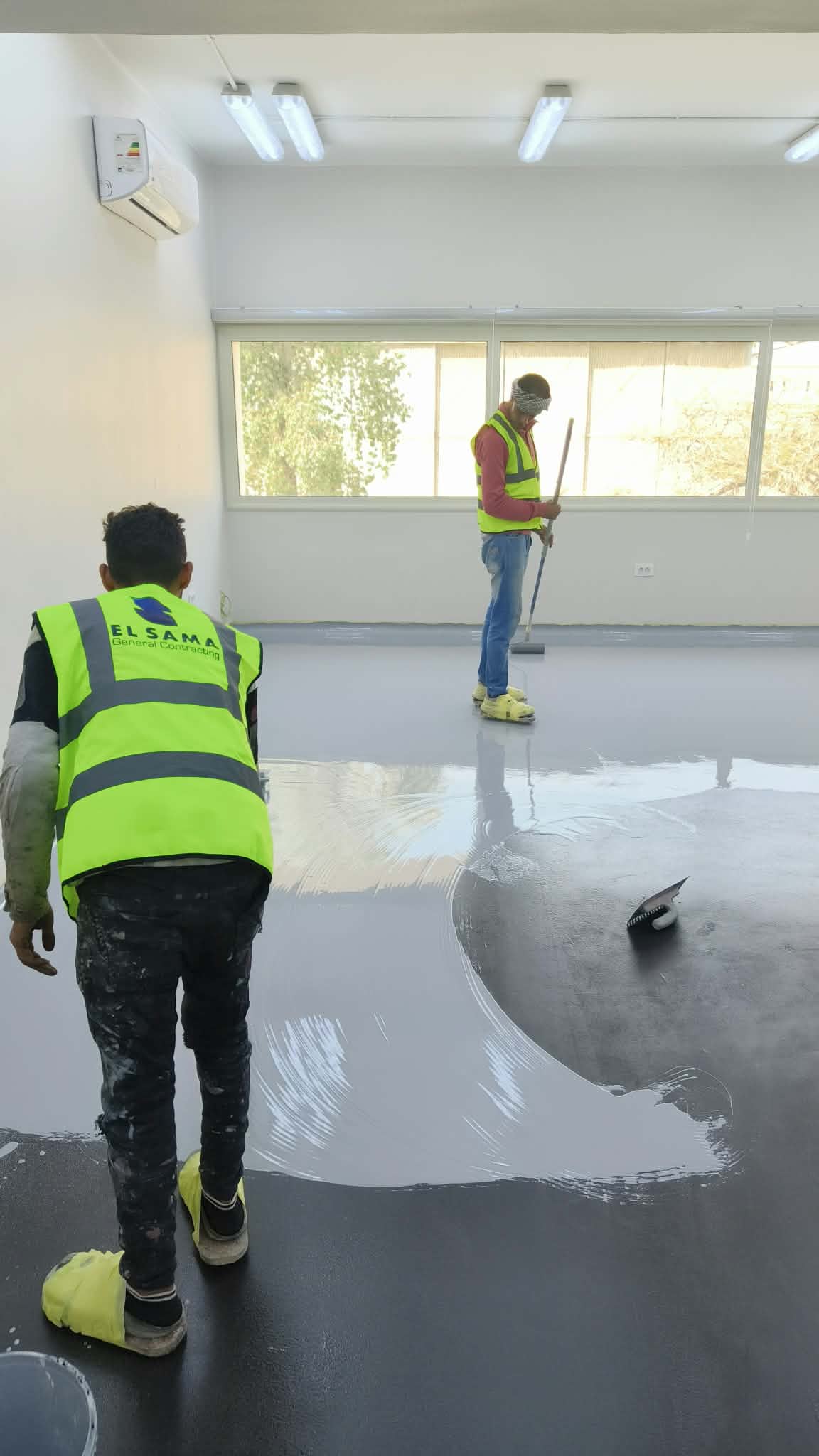 Lexstone applicators spreading self-leveling epoxy compound on site