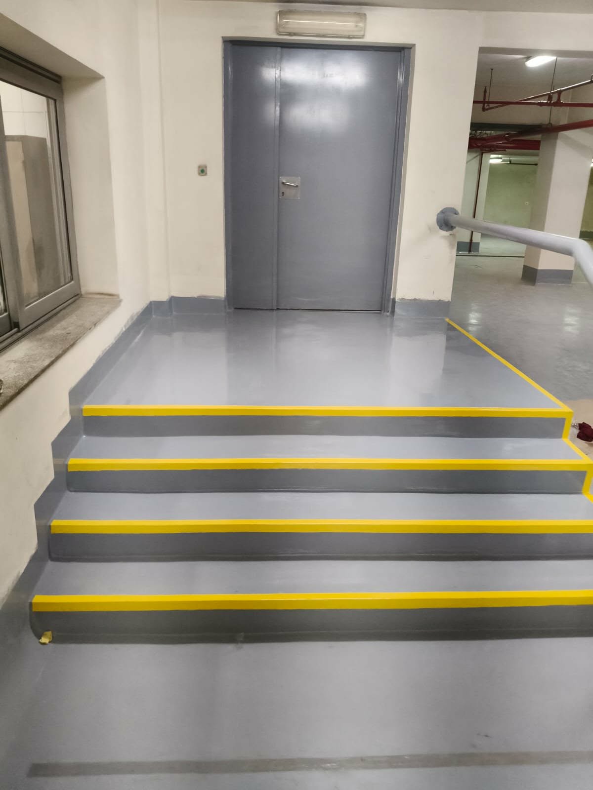 Epoxy-coated stairwell with yellow safety nosing on each step